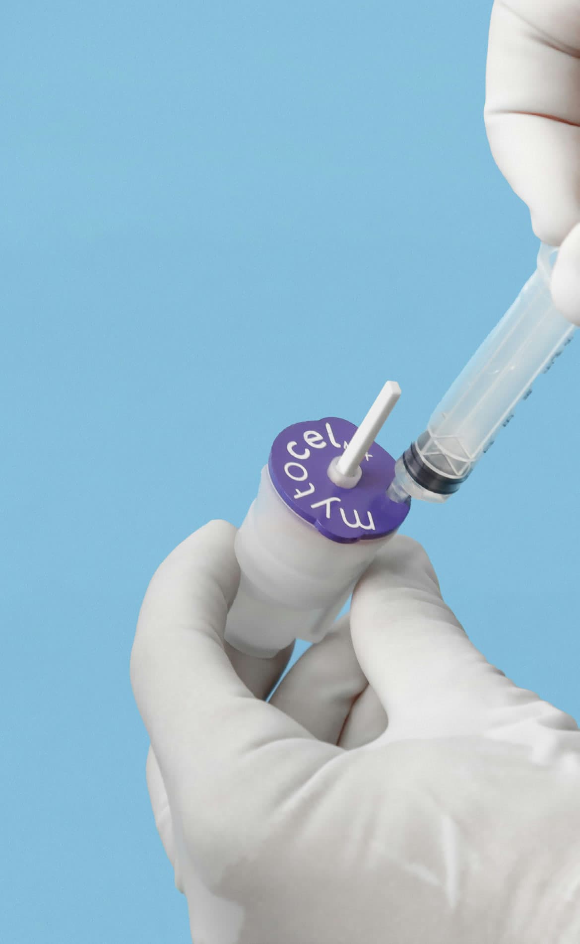 Gloved hands drawing the prepared suspension from the single-use cartridge with a syringe